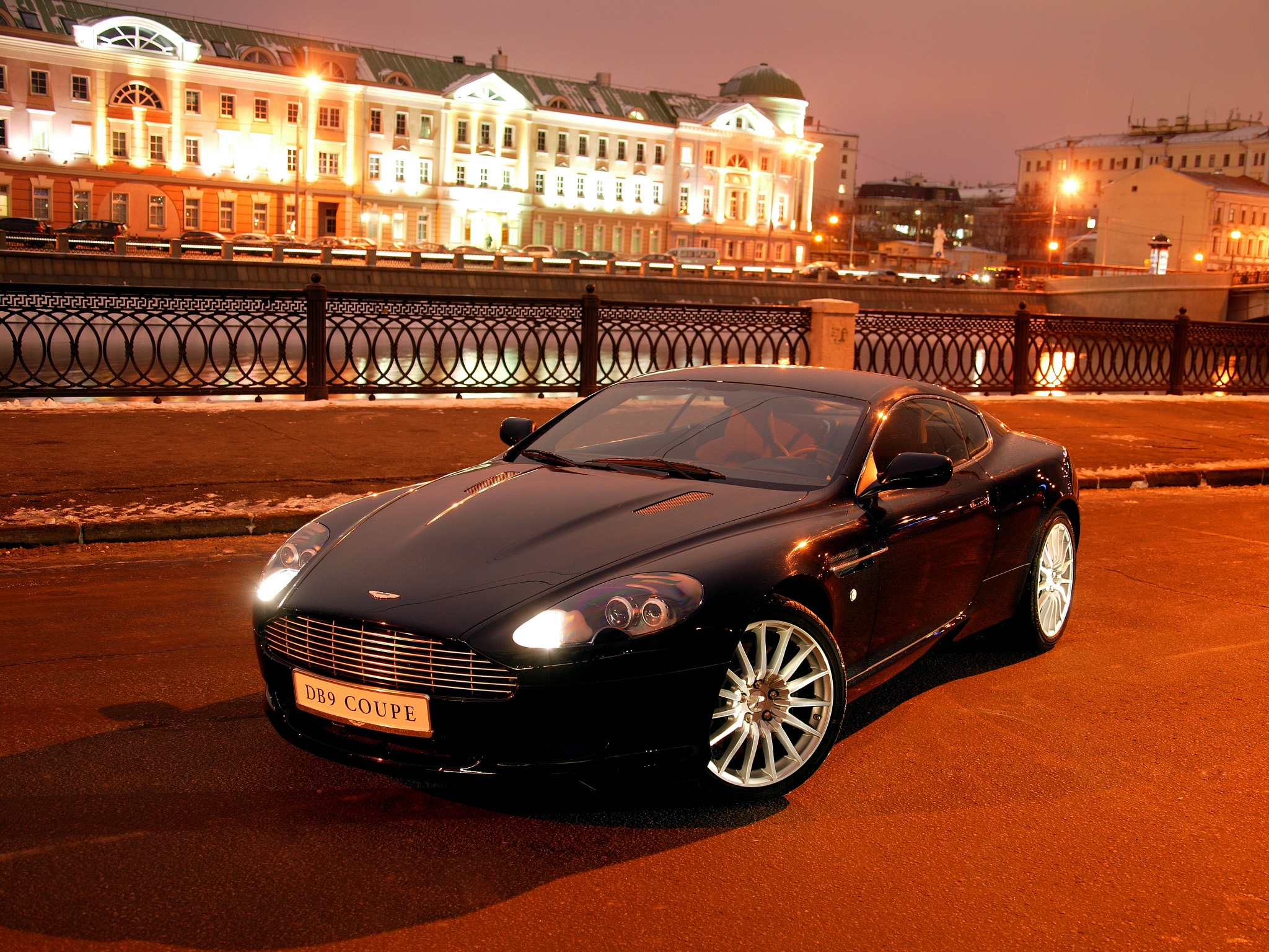 Скачать aston martin, db9, 2004, черный, вид спереди, стиль, авто, астон мартин, город, дома, огни, асфальт обои на рабочий стол