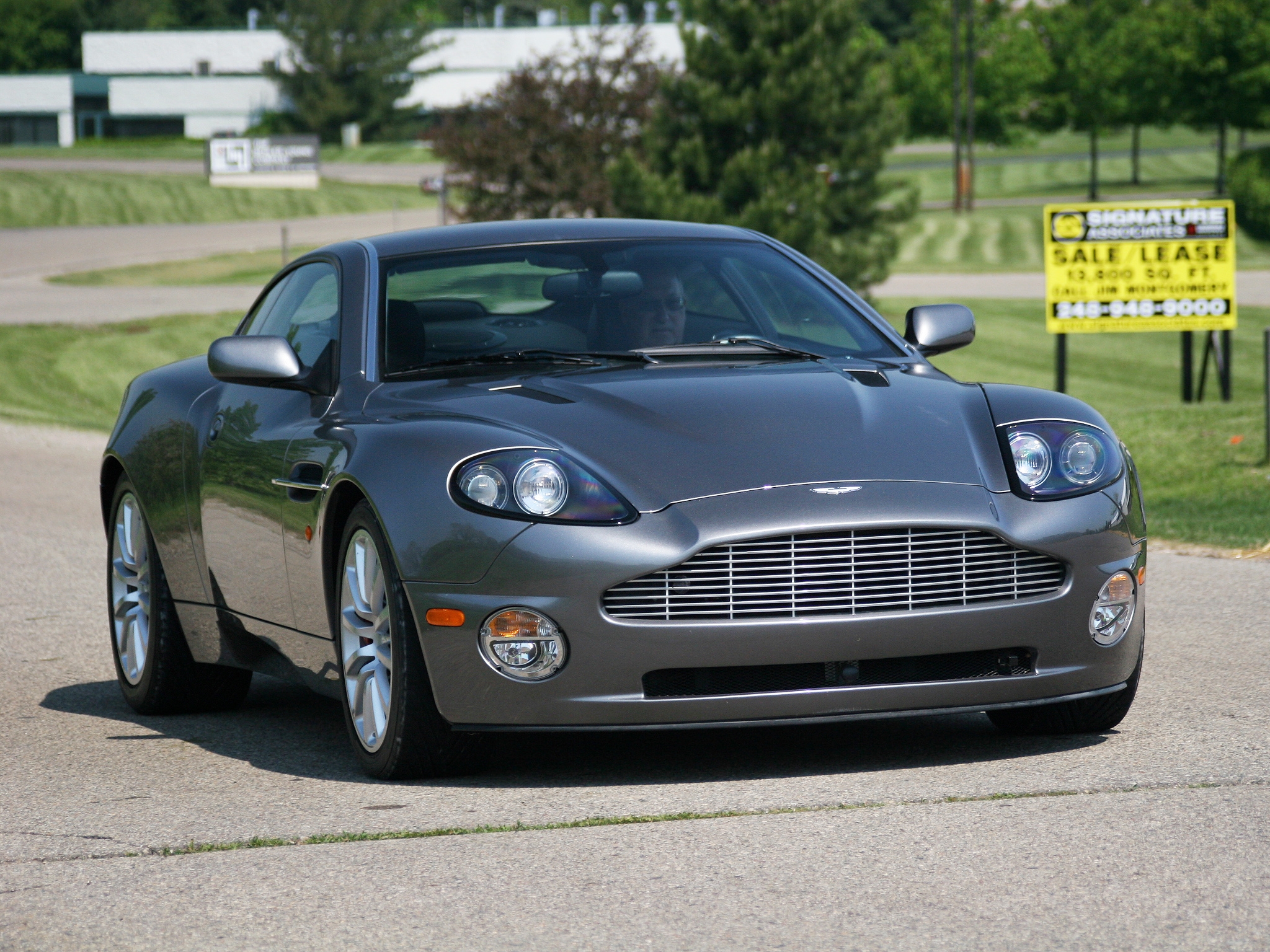 Скачать aston martin, v12, vanquish, 2001, серый, вид спереди, астон мартин, деревья обои на рабочий стол