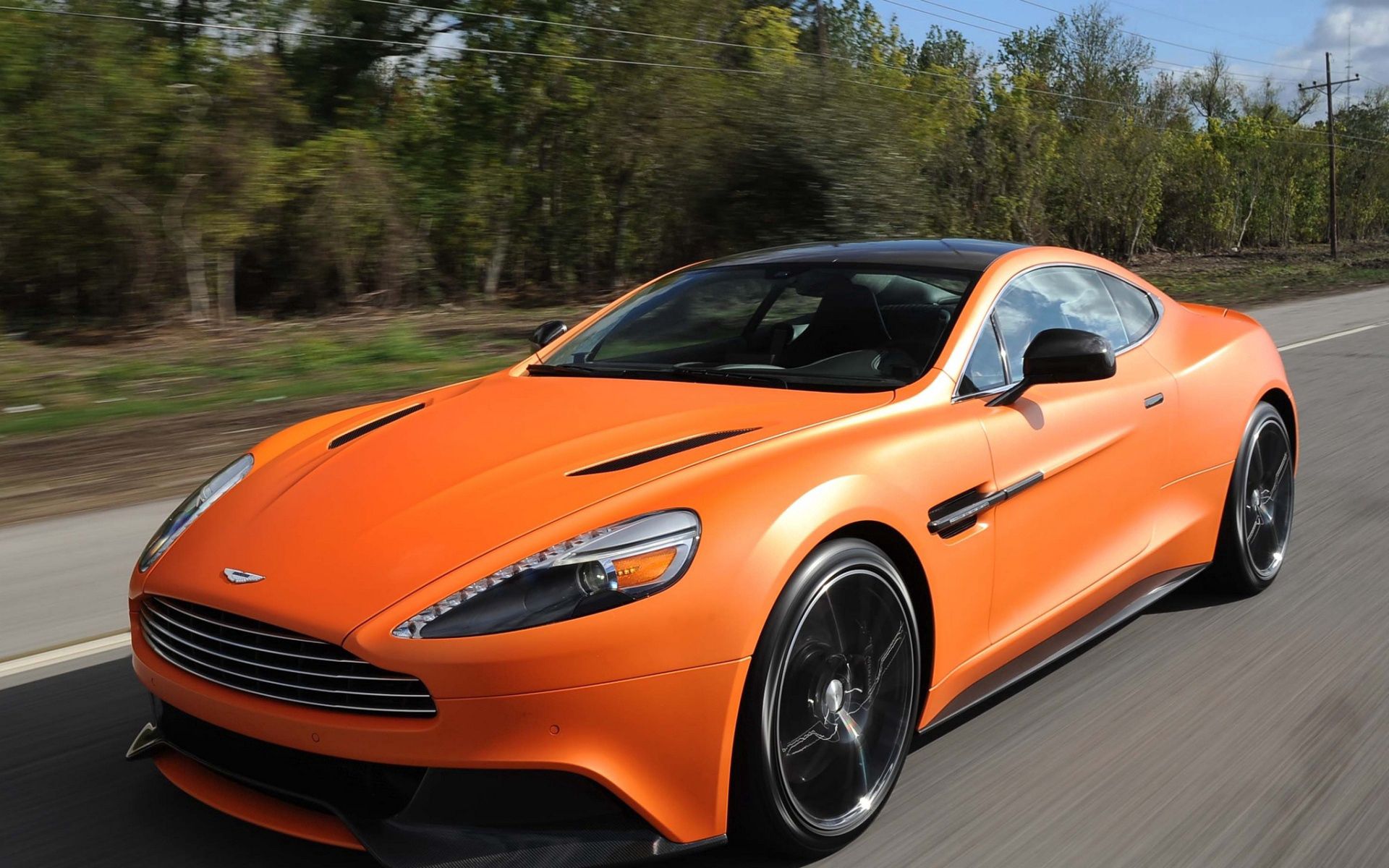 Скачать aston martin, vanquish orange, оранжевый, скорость, вид спереди обои на рабочий стол