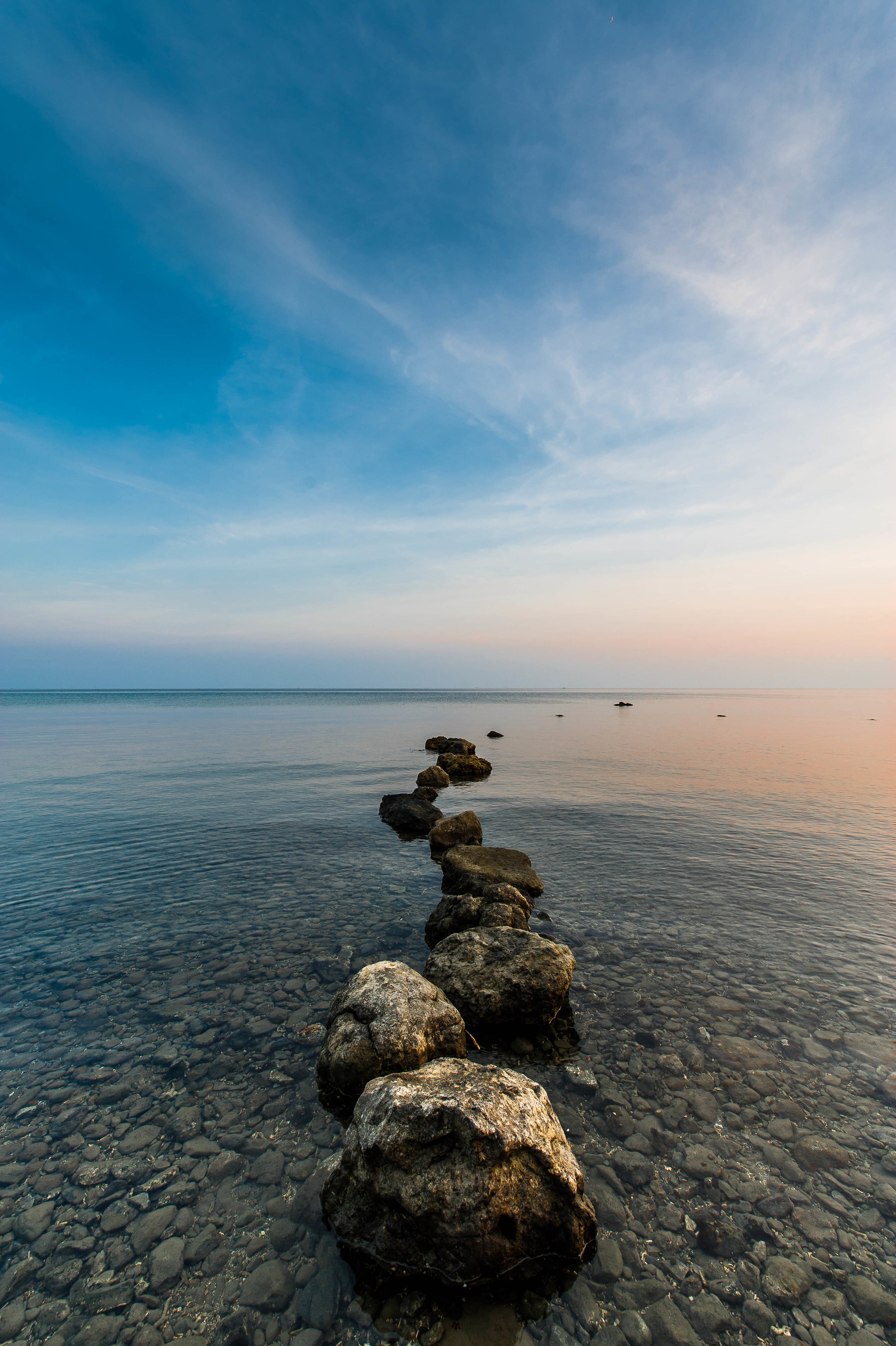 Скачать камни, галька, море, горизонт, небо обои для телефона